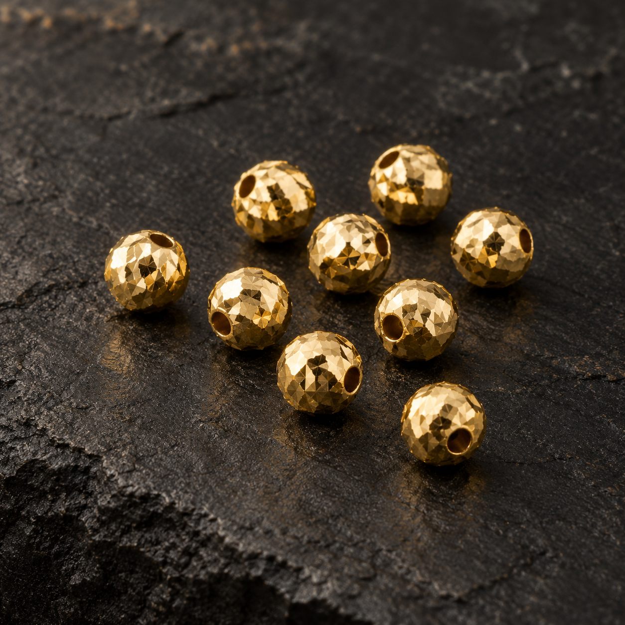 Imagen ilustrativa provisional de bolitas diamantadas de oro amarillo.